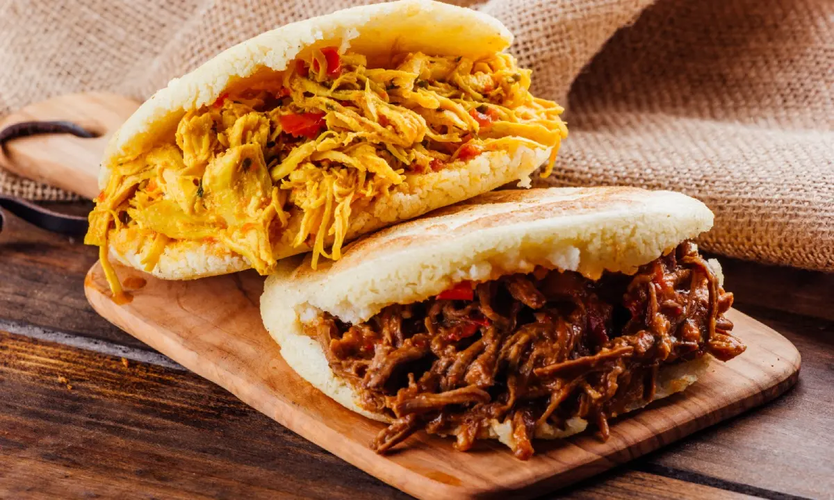Tacos de carne deshebrada y pollo con chimichurri en pan tipo arepa