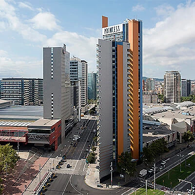 Torre &ldquo;Princess&rdquo; en zona urbana con edificios y cielo parcialmente nublado
