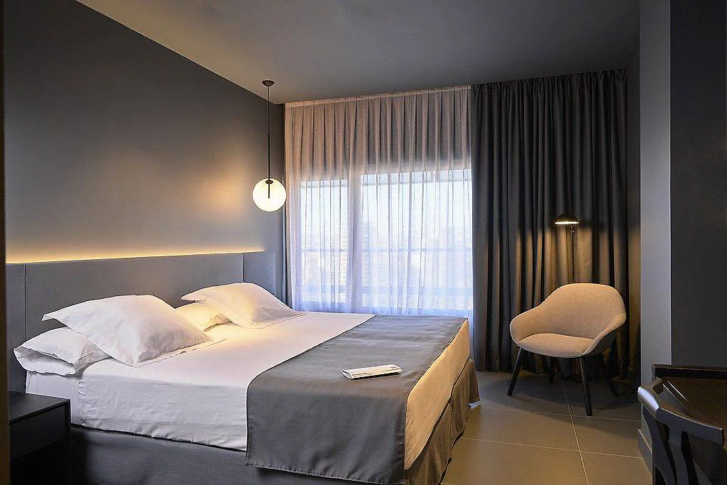Dormitorio moderno con cama doble, silla y cortinas oscuras y claras