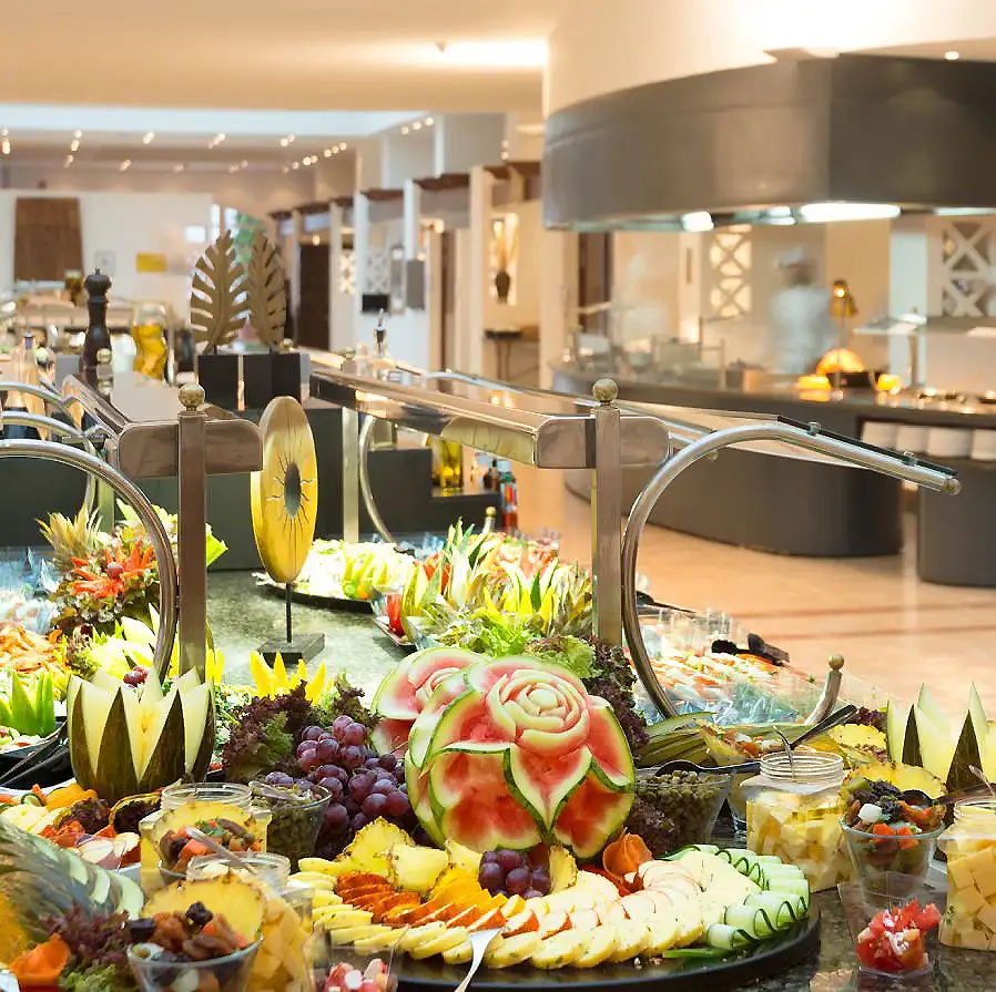 Buffet de frutas y verduras en hotel, con ensaladas y bandejas.