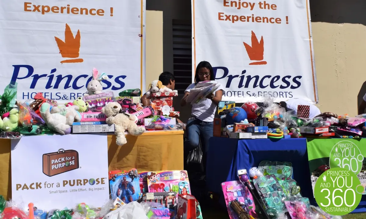Stand ben&eacute;fico de Princess Hotels con mesas llenas de peluches y regalos