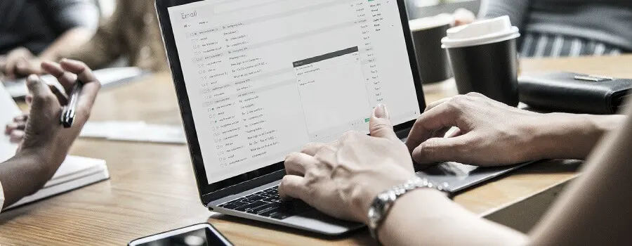 Personas trabajando en un port&aacute;til con un documento de correo electr&oacute;nico.
