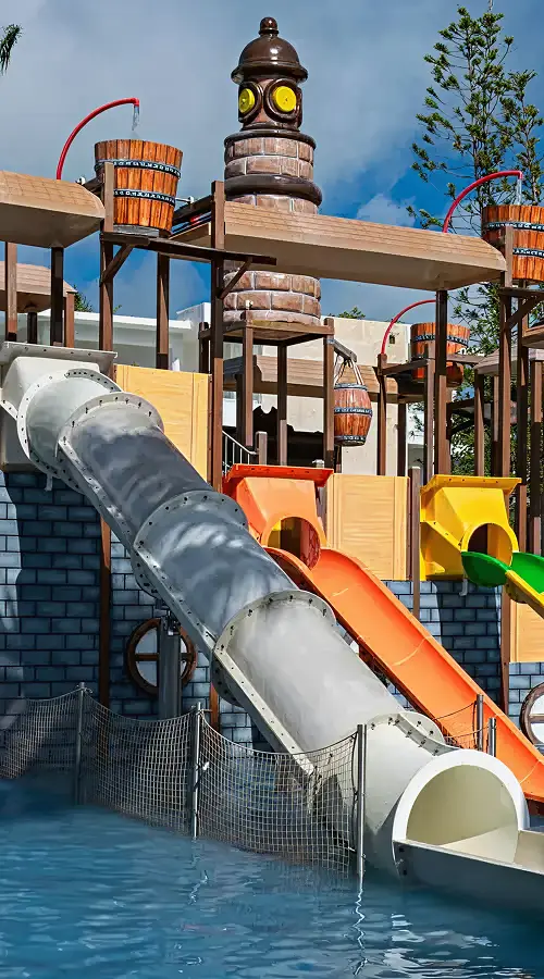Parque acu&aacute;tico con toboganes y torres sobre una piscina azul