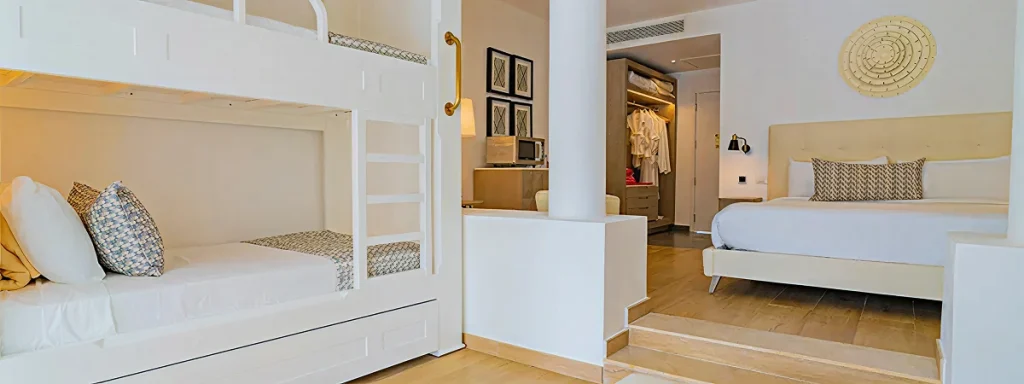 Dormitorio moderno con cama doble, literas blancas y zona de paso interior