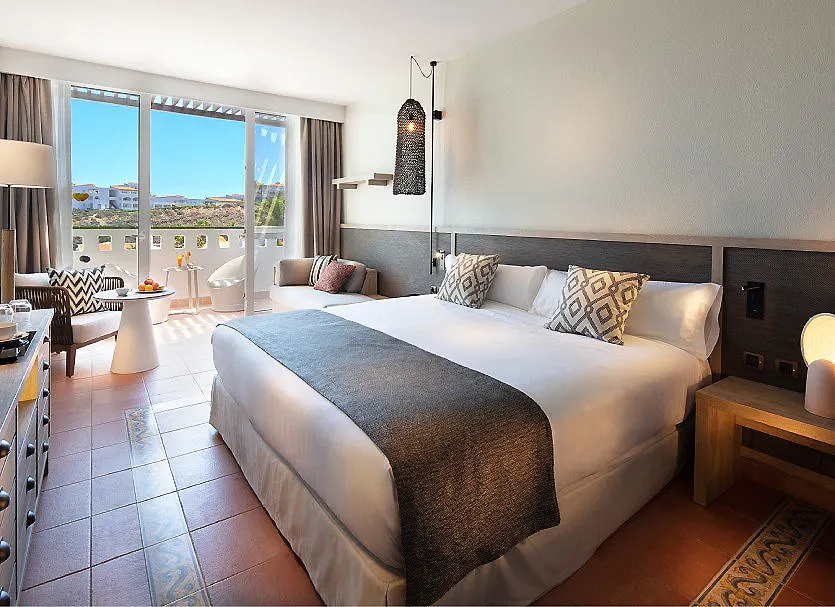 Habitaci&oacute;n hotelera luminosa con cama doble y balc&oacute;n con vista al mar