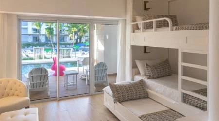Sala luminosa con sof&aacute; y litera en un cuarto con salida al balc&oacute;n