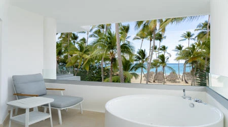 Balc&oacute;n con jacuzzi y vista al mar entre palmeras y palmeras tropicales