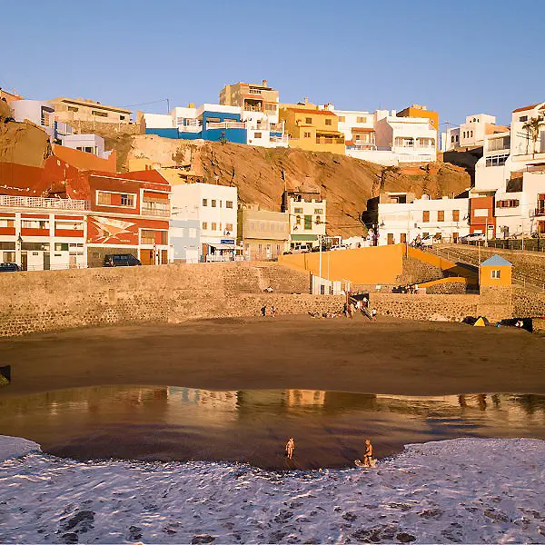 Casas blancas y naranja junto al r&iacute;o, paisaje urbano al atardecer