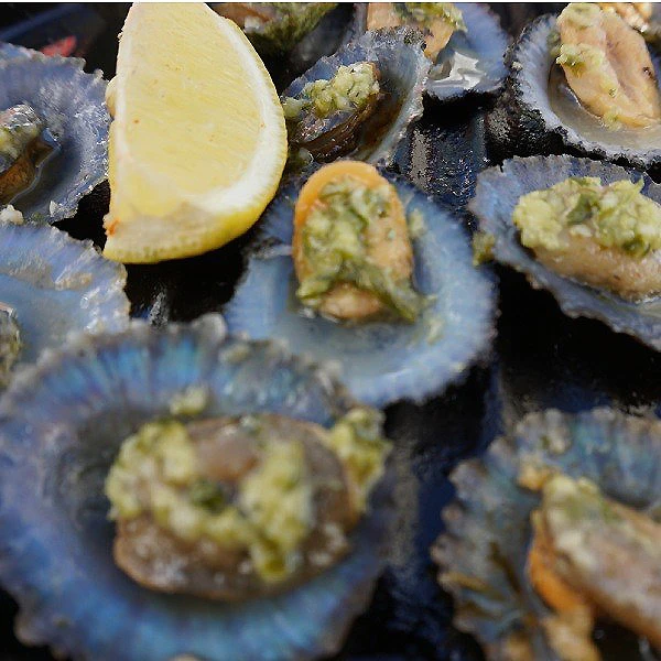Rodajas de lim&oacute;n y trozos de verduras as&aacute;ndose en una parrilla caliente