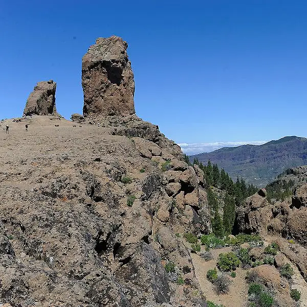 Rocas en la cima con cielo azul y valle al fondo