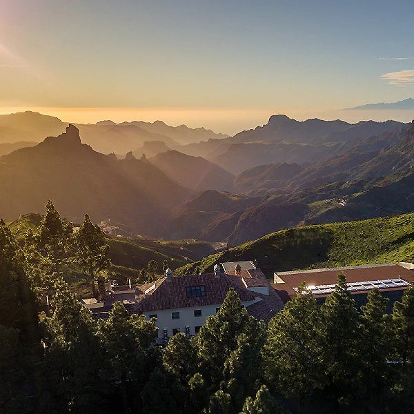 Pueblo rural con casas blancas entre monta&ntilde;as al atardecer, niebla y luz solar
