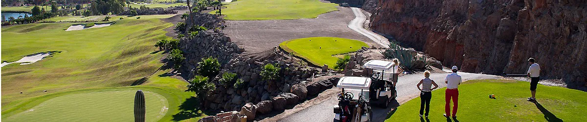 Paisaje costero con acantilado, golf y personas caminando cerca de un buggy