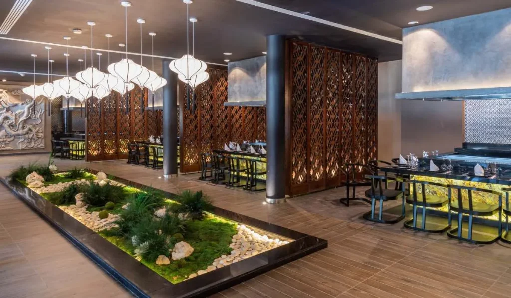 Interior de restaurante moderno con jard&iacute;n interior, mamparas decorativas y mesas