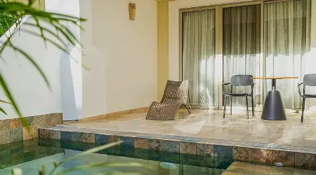 Piscina interior con zona de estar y puertas con cortinas.