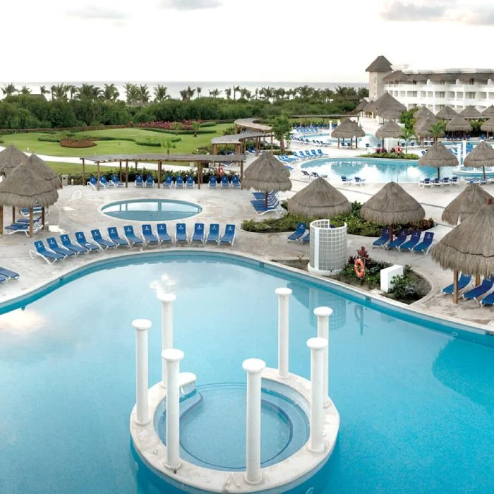 Piscinas con tumbonas y caba&ntilde;as junto al mar en un resort tropical