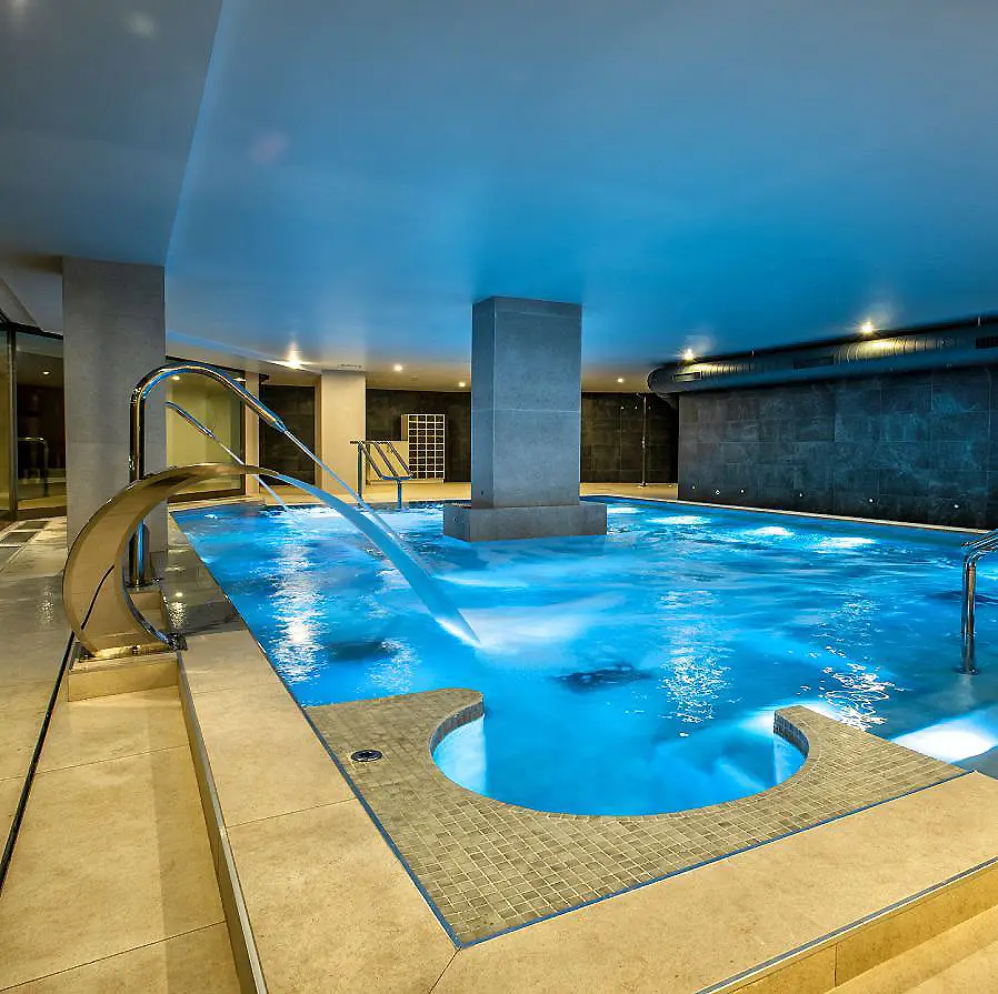 Piscina cubierta con zona de relajaci&oacute;n y chorros de agua.