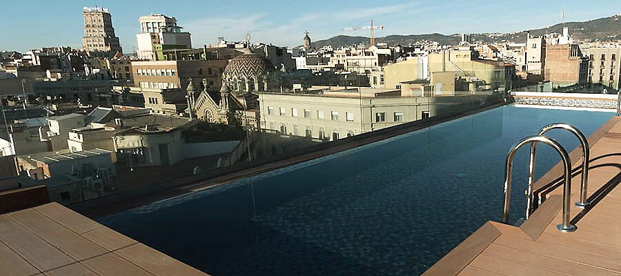 Piscina en azotea con vistas al casco antiguo y edificios de la ciudad.