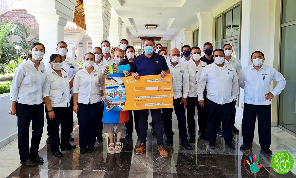 Grupo de m&eacute;dicos y enfermeras con cubrebocas y cartel en pasillo blanco