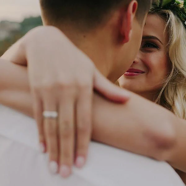 Pareja abrazada y sonriente, mir&aacute;ndose con ternura al aire libre