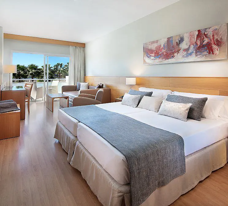 Habitaci&oacute;n de hotel moderna con camas, sof&aacute; y cuadro abstracto en la pared