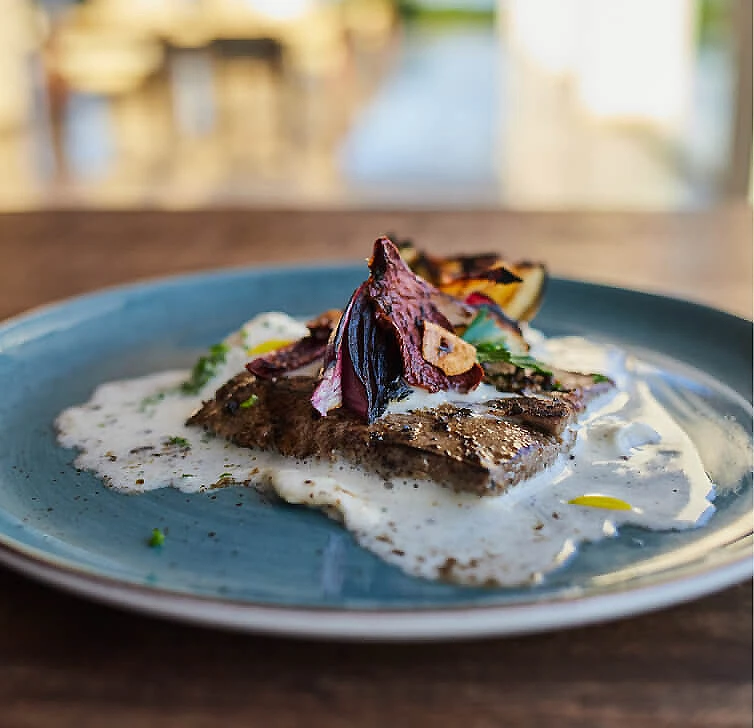 Plato azul con huevo frito, esp&aacute;rragos y tostada crujiente sobre la mesa
