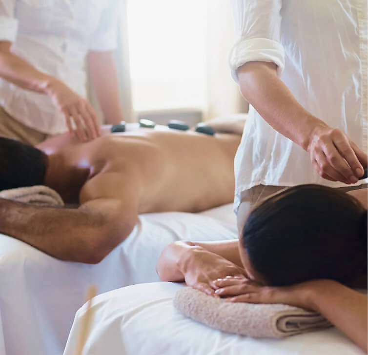 Masaje terap&eacute;utico en camilla, con manos de terapeuta sobre la espalda