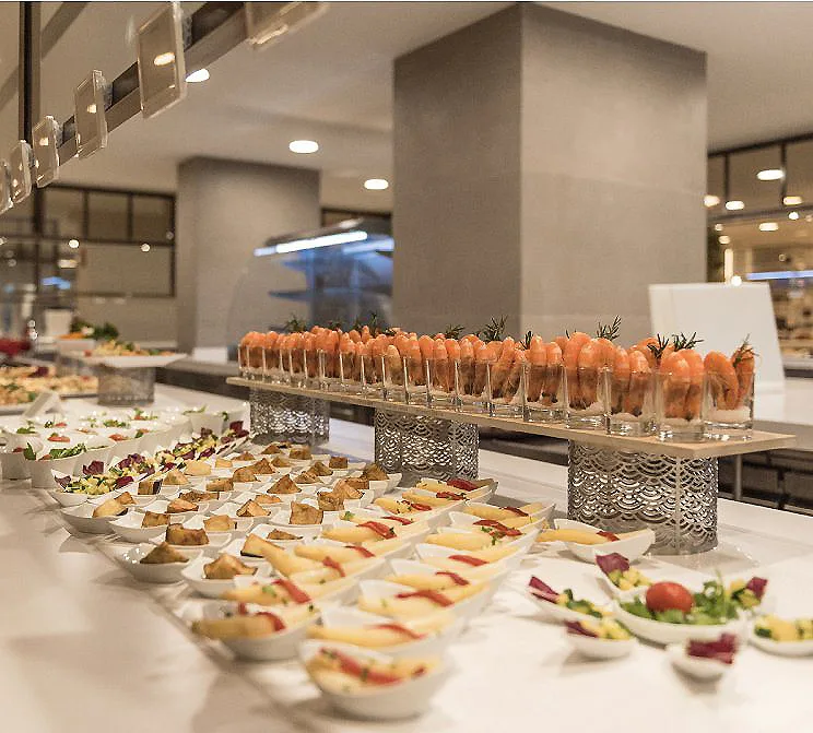 Mesa buffet con canap&eacute;s y c&oacute;cteles de frutas en bandejas y vasos.