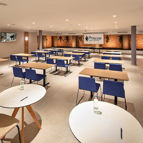 Sala de desayunos con mesas blancas y sillas azules, letrero &ldquo;Princess&rdquo;.