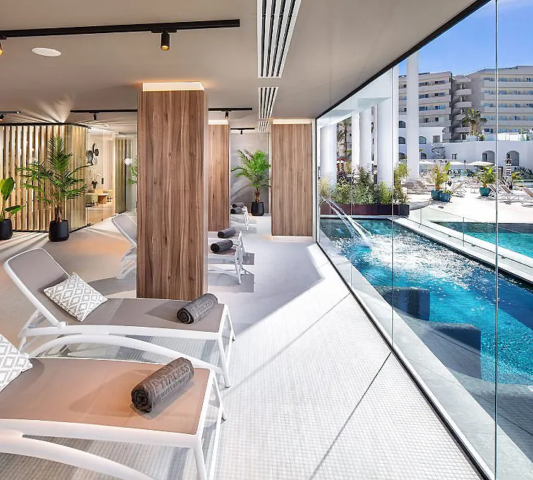 Terraza con piscina, tumbonas y vista a un edificio urbano moderno.