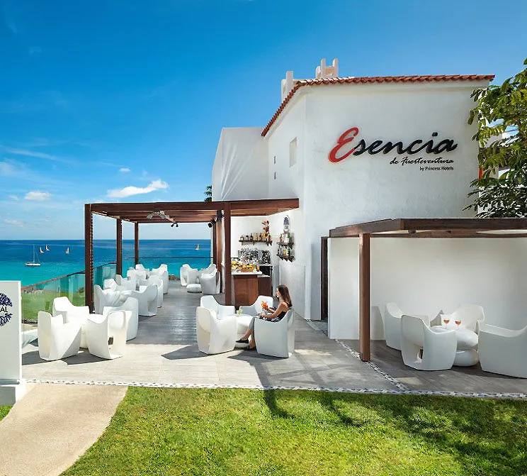 Terraza junto al mar en hotel &ldquo;Esencia&rdquo; con zona de bar y mesas blancas