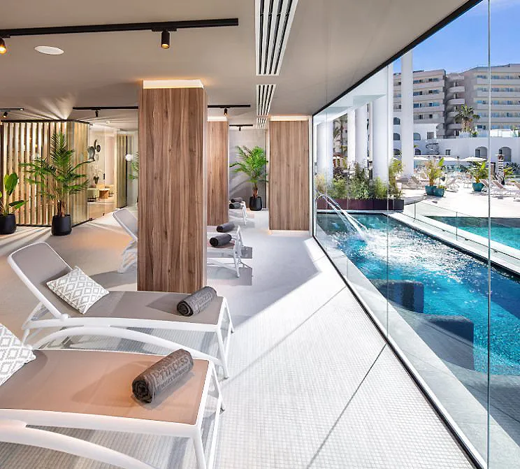 Terraza moderna con piscina y tumbonas, rodeada de palmeras y madera.