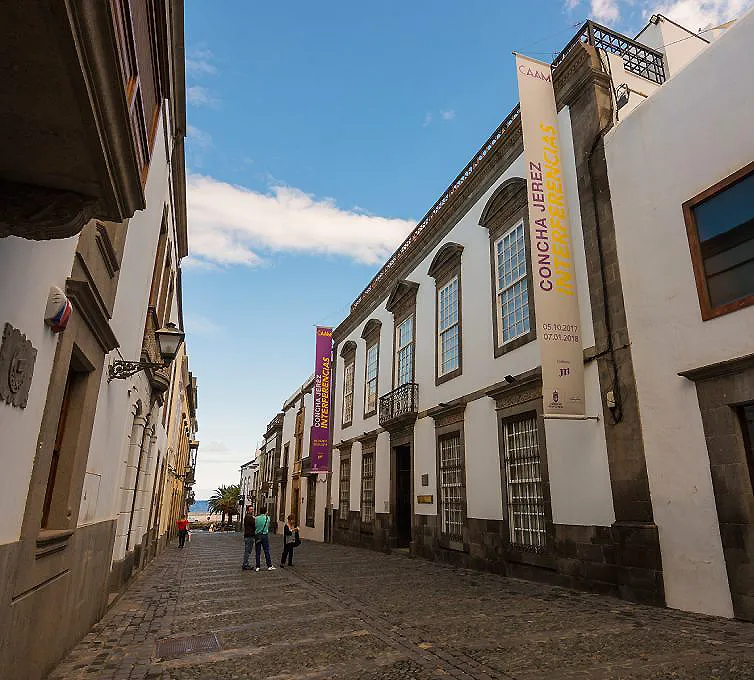 Calle con edificios hist&oacute;ricos y cartel de exposici&oacute;n en Tenerife, Espa&ntilde;a.