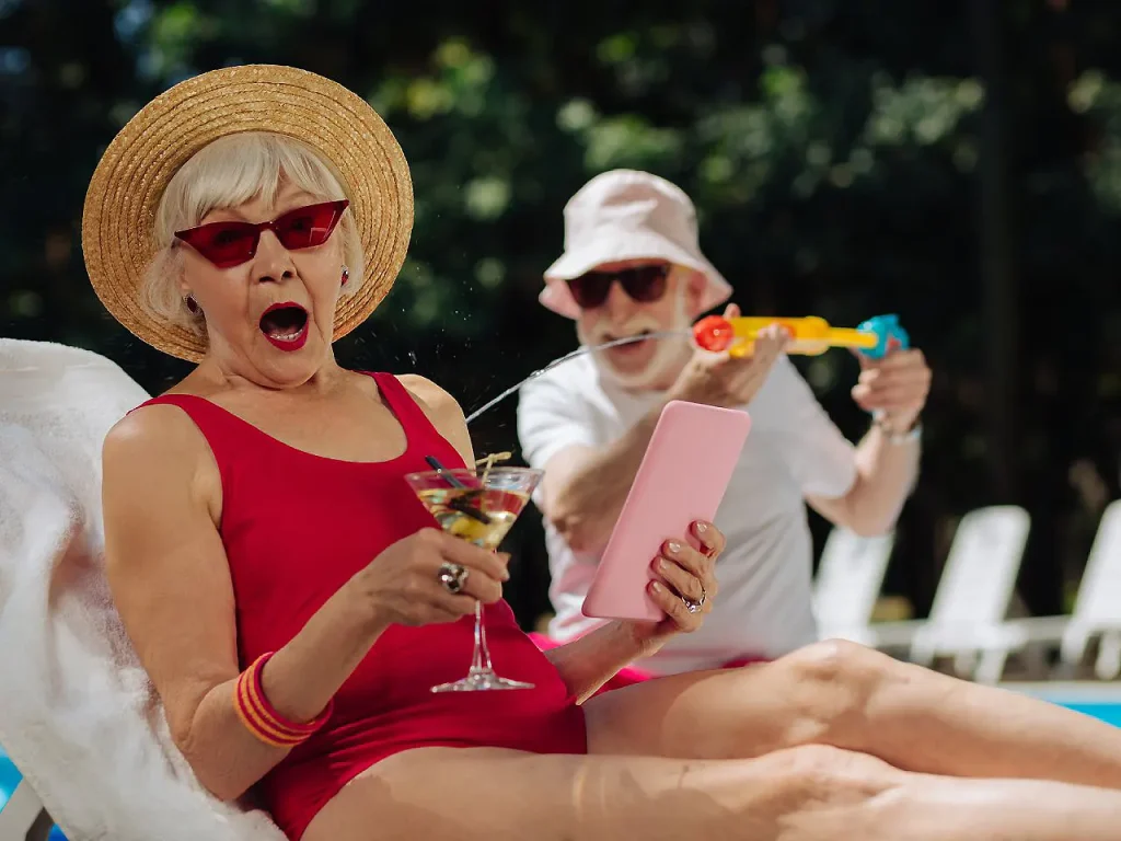 Mujer con sombrero de paja y gafas rojas, en una fiesta al aire libre