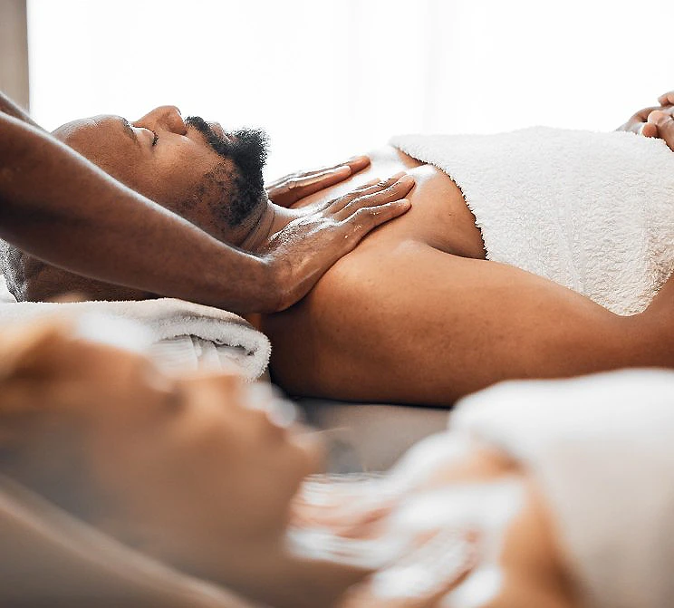 Masaje facial y corporal en spa, terapeuta masajeando a una persona acostada
