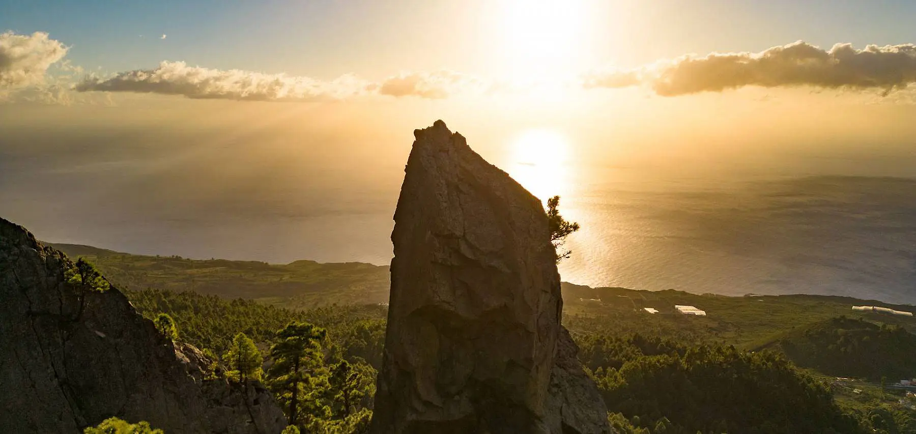 Pico de roca en acantilado con luz del atardecer sobre el mar