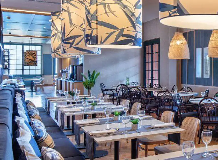 Sala de restaurante moderna con mesas decoradas y pared con graffiti abstracto