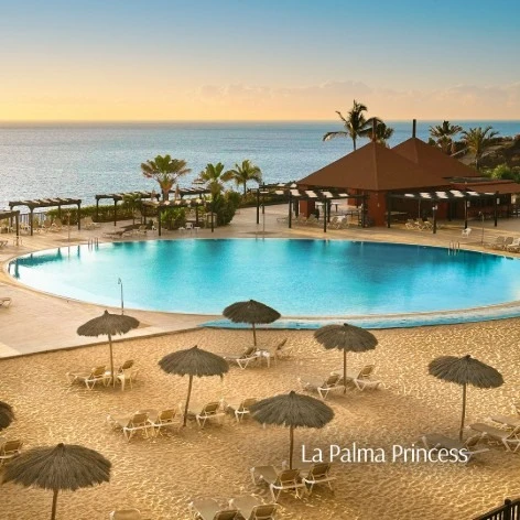 Piscina y palmeras en el hotel La Palma Princess al atardecer