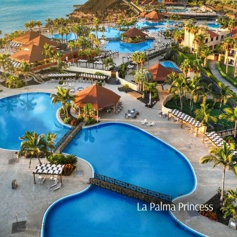 Piscina y palmeras en hotel La Palma Princess frente al mar