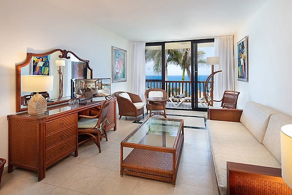 Sala de estar con sof&aacute;, mesa de centro y vista al mar desde la ventana