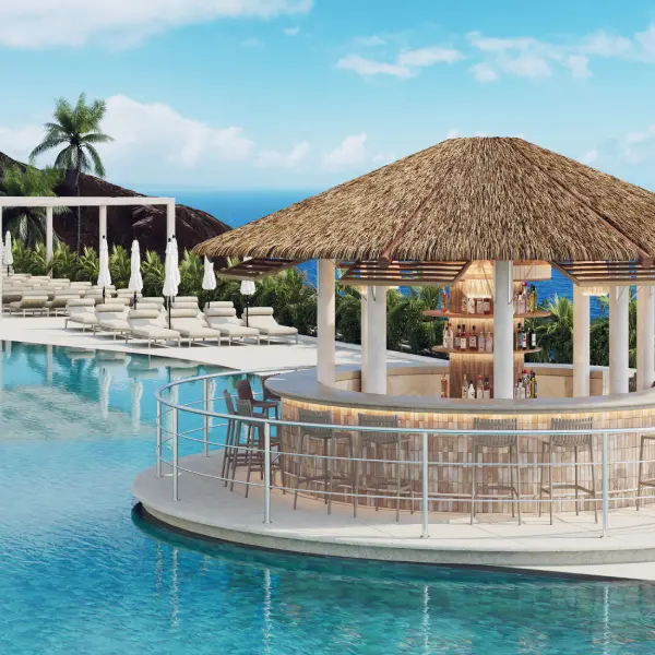 Piscina con terraza y sombrilla de paja frente al mar.