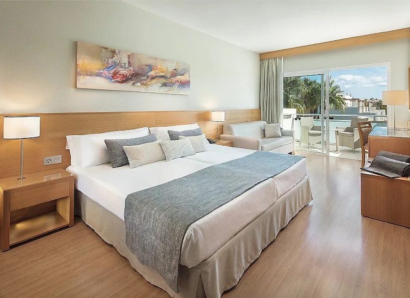 Dormitorio moderno con cama doble, l&aacute;mparas y acceso a balc&oacute;n.