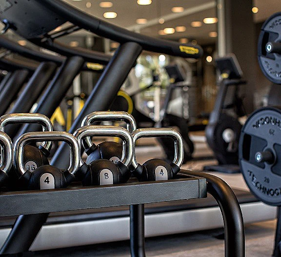 Pesas rusas y mancuernas en un gimnasio, con kettlebells frente al equipo