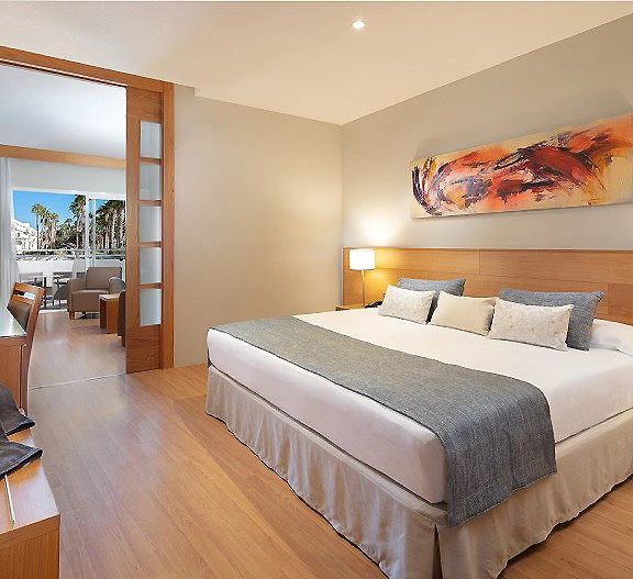 Dormitorio moderno con cama doble, l&aacute;mpara y cuadro abstracto en pared