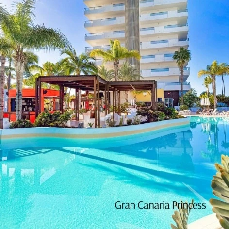 Piscina del hotel Gran Canaria Princess con palmeras y edificio al fondo