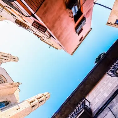 Perspectiva de casas y balcones apuntando al cielo azul desde abajo