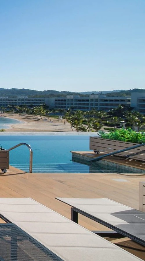 Terraza con piscina y vista al mar desde un resort costero.