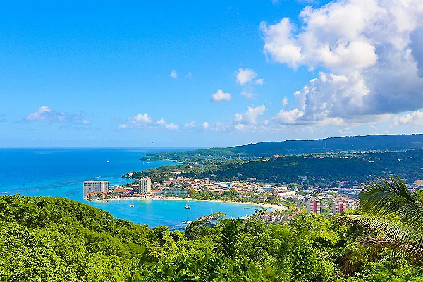 Vista panor&aacute;mica de la costa con bah&iacute;a, edificios y vegetaci&oacute;n tropical.