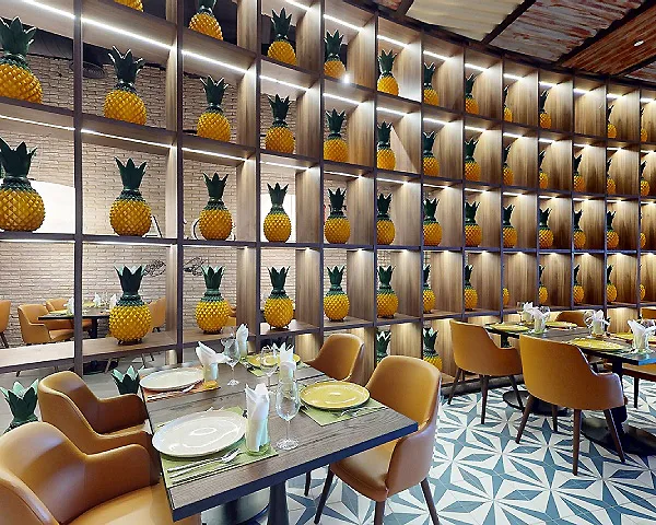 Comedor con mesas puestas y pared de pi&ntilde;as decorativas en estantes iluminados