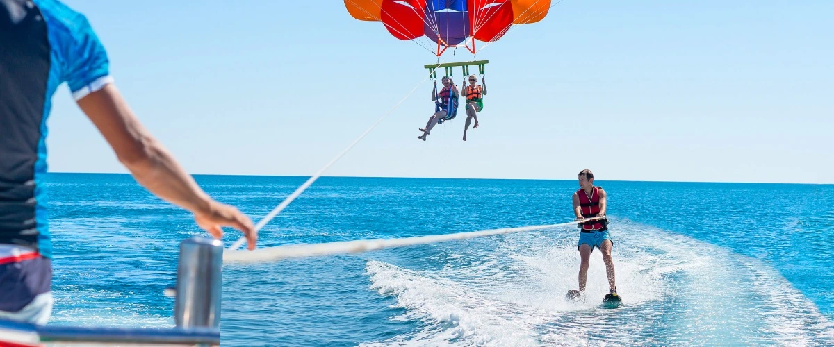 Paracaidistas sobre el mar: uno sale desde un bote y otro desciende con paraca&iacute;das
