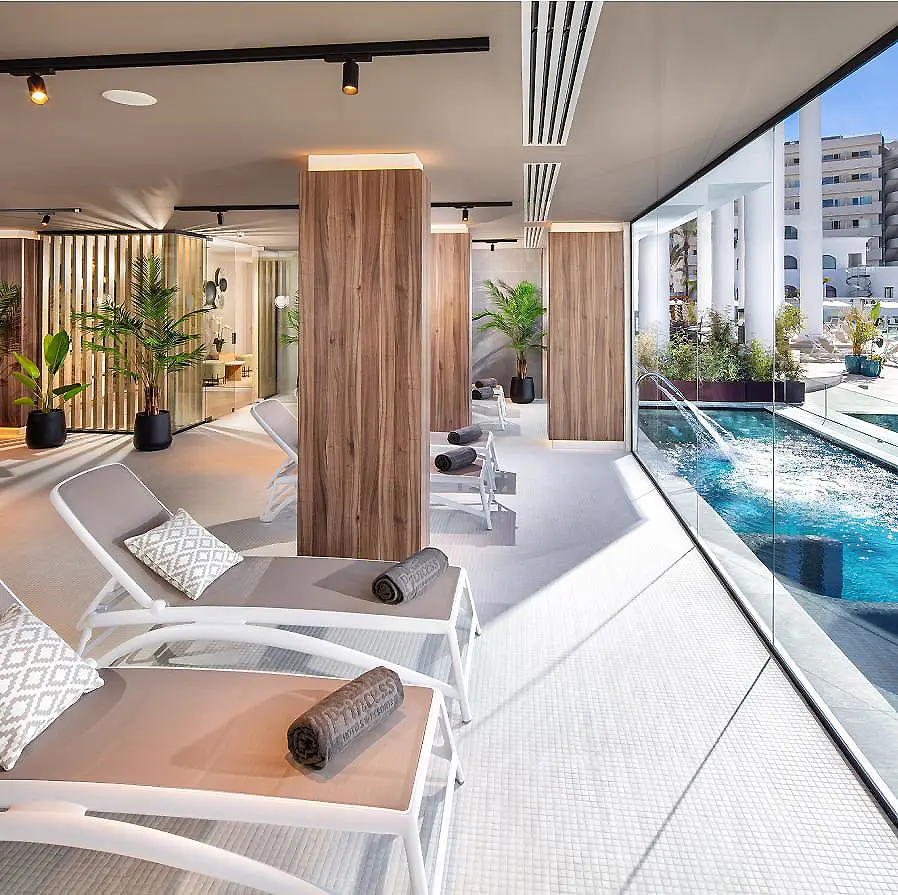 Terraza moderna con piscina y tumbonas, columnas de madera y plantas.